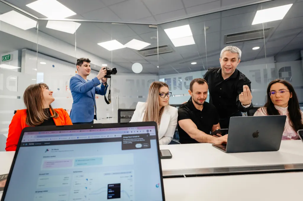 Membri ai echipei DWF analizând împreună un proiect pe laptop