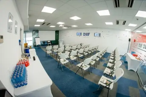 Sala de atelier pregătită la sediul DWF, cu mesele aranjate în formă de U