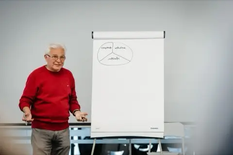 Vorbitor explicând o schemă desenată pe flipchart