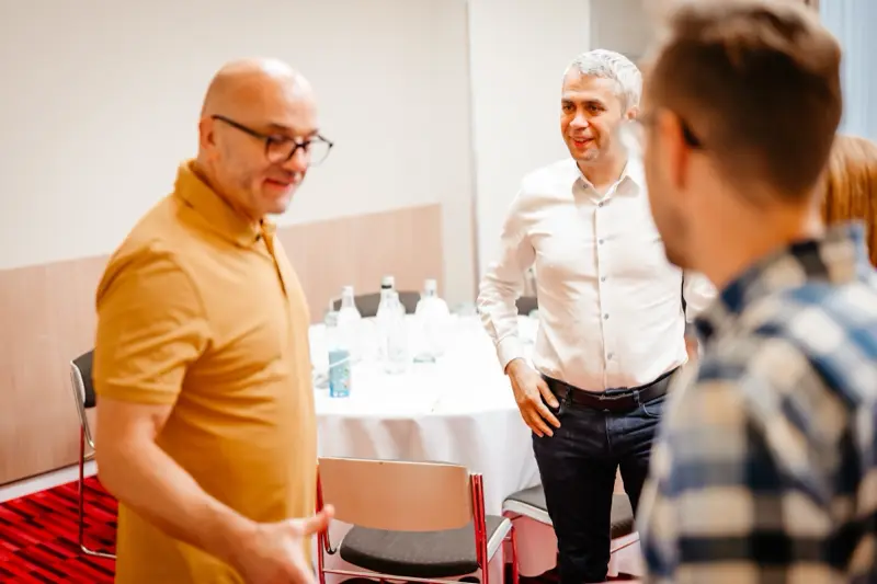 Participanți salutându-se la începutul întâlnirii