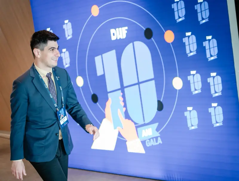 Invitat în fața photo wall-ului aniversar DWF 10 ani