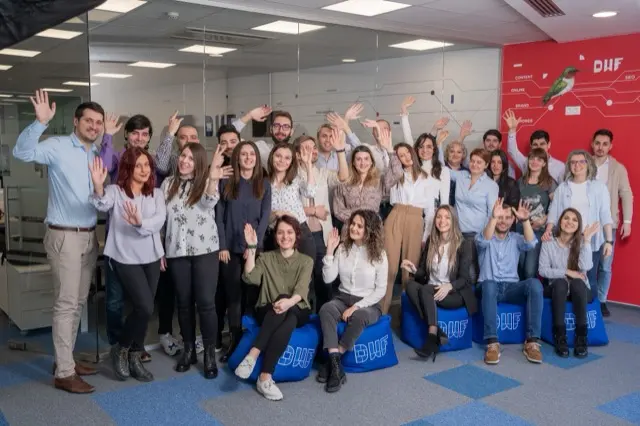 Fotografie de grup a echipei DWF, salutând, în biroul agenției